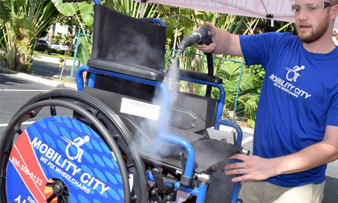 A worker sanitizing a wheelchair