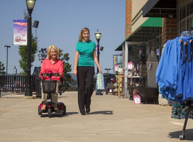 A mother in wheelchair and her daughter shopping outdoors