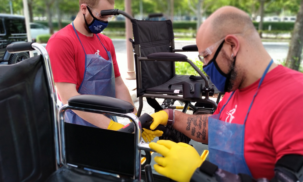 Two Mobility City employees sanitize wheelchairs